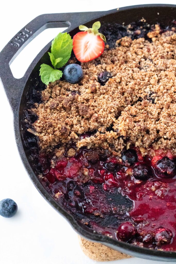 Paleo Berry Cobbler from A Thousand Crumbs A perfectly sweet paleo berry cobbler made with three kinds of berries and #autumnsgold paleo granola in the topping. Add coconut whipped cream for the ultimate #paleo treat. #athousandcrumbs #paleo #berry #cobbler #strawberry #blueberry #raspberry #coconutwhippedcream