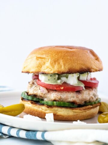 Greek Chicken Burgers full of flavor, and so easy to make! #athousandcrumbs #greekfood #chickenburgers #healthydinner #dinnerrecipe #burgerrecipe