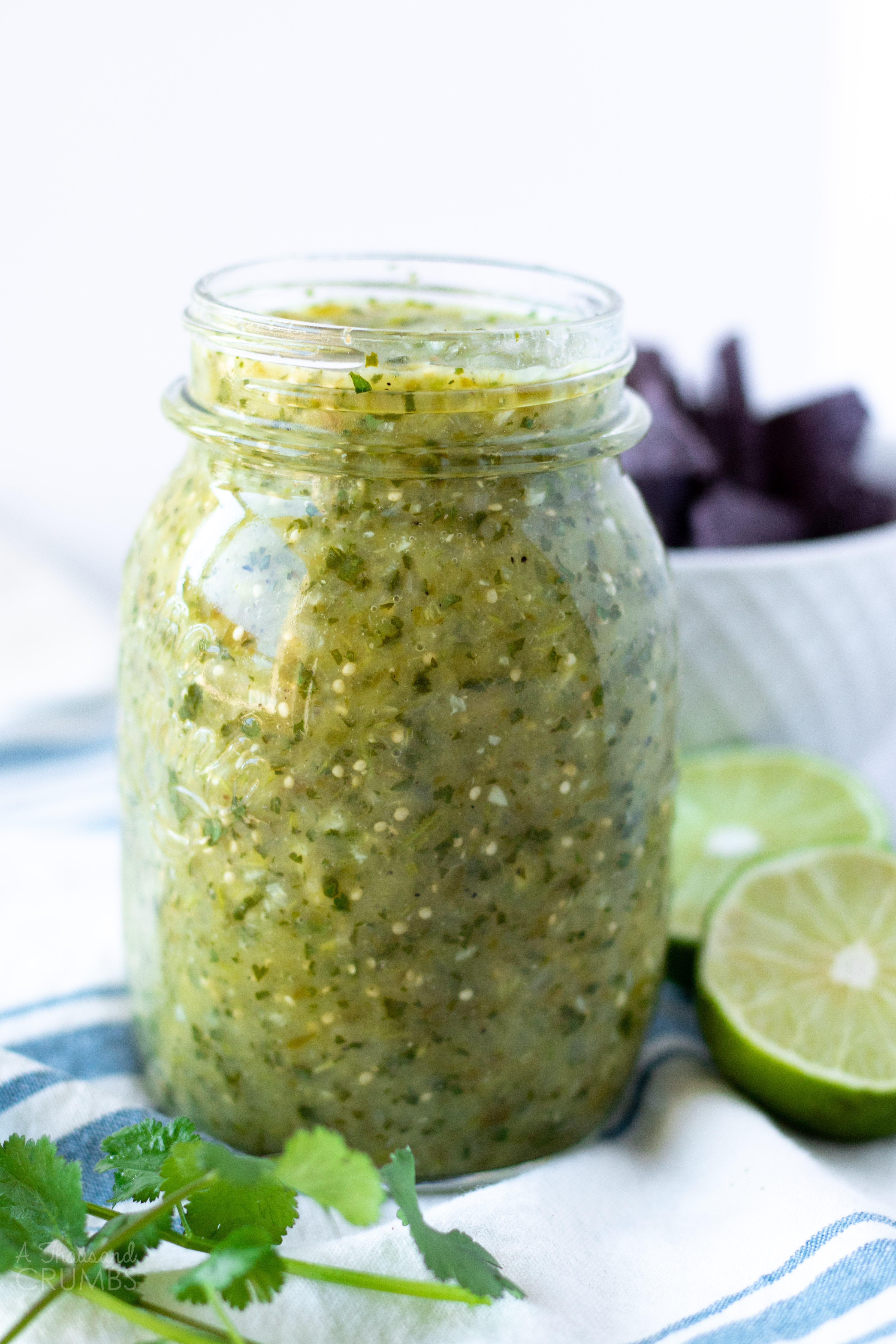 Green tomatillo salsa is great on just about anything. It makes a fantastic snack, a wonderful topping on eggs, and an absolutely necessary addition to taco night. This recipe is so easy, and only a handful of ingredients. #athousandcrumbs #tomatillosalsa #mexicanfood #paleo #salsa #homemade