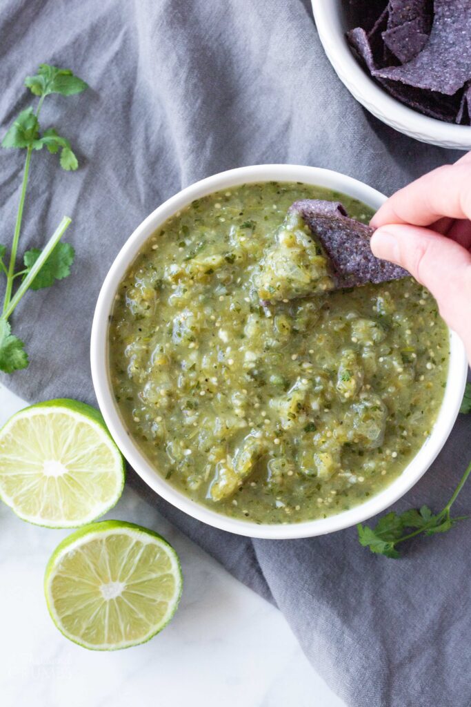 Green tomatillo salsa is great on just about anything. It makes a fantastic snack, a wonderful topping on eggs, and an absolutely necessary addition to taco night. This recipe is so easy, and only a handful of ingredients. #athousandcrumbs #tomatillosalsa #mexicanfood #paleo #salsa #homemade
