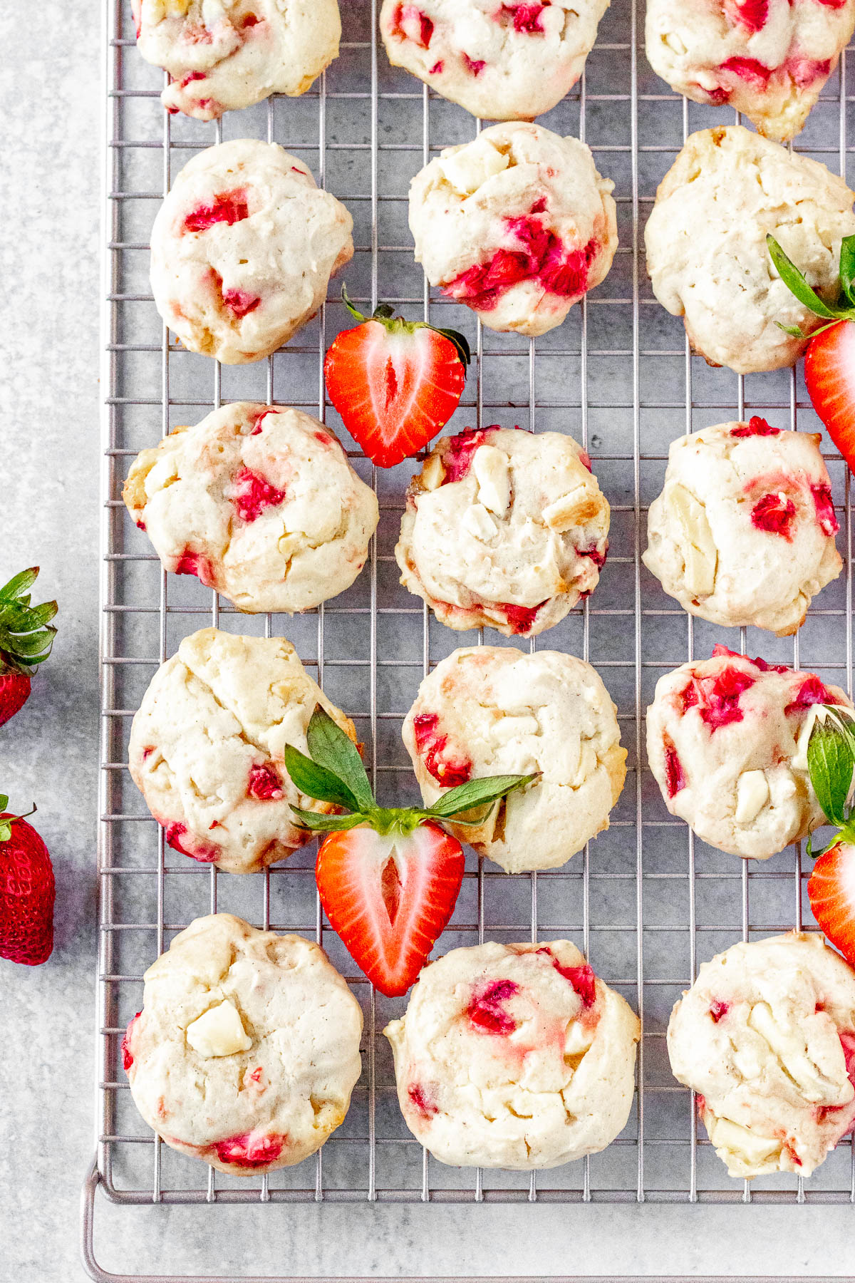 Rows of fresh strawberry cheesecake cookies on a cooling rack.